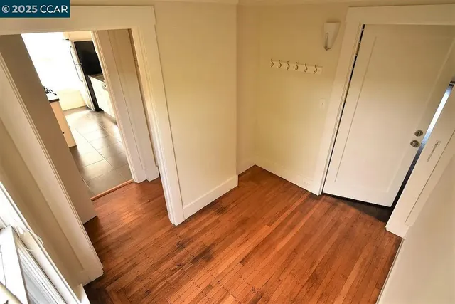 an empty room with wooden floor and a window