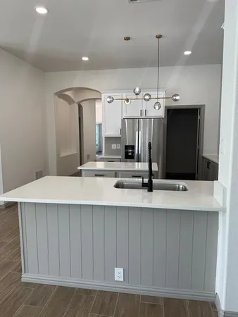 a view of a kitchen with stainless steel appliances a large counter top