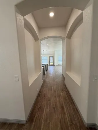 a view of a hallway with wooden floor and staircase