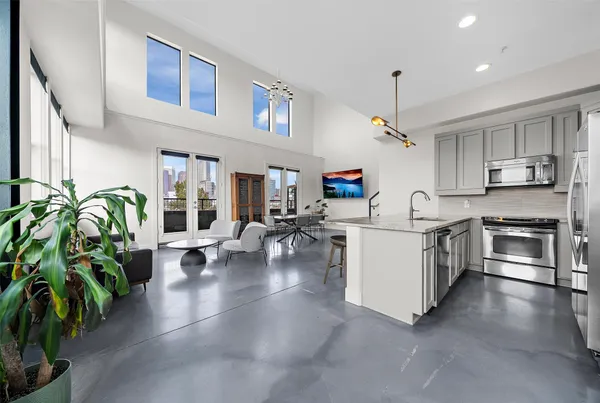 a kitchen with stove a refrigerator and a potted plant