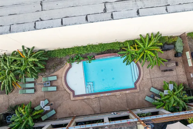 a view of backyard with swimming pool and seating space