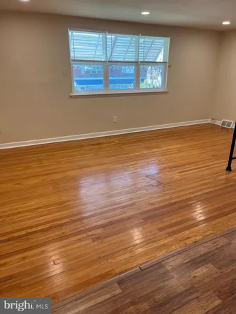 an empty room with wooden floor and entrance
