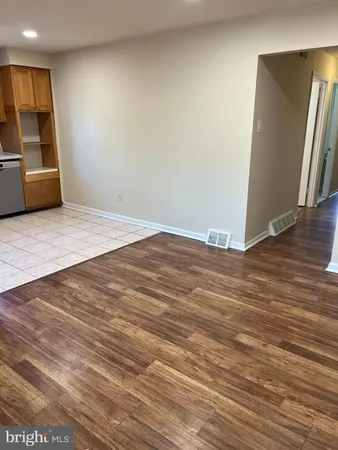 an empty room with wooden floor and stairs