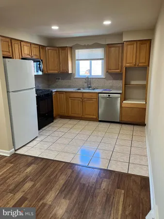 a kitchen with granite countertop a refrigerator and a sink