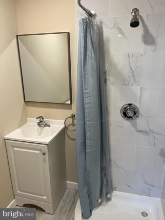 a bathroom with a sink and mirror with shower