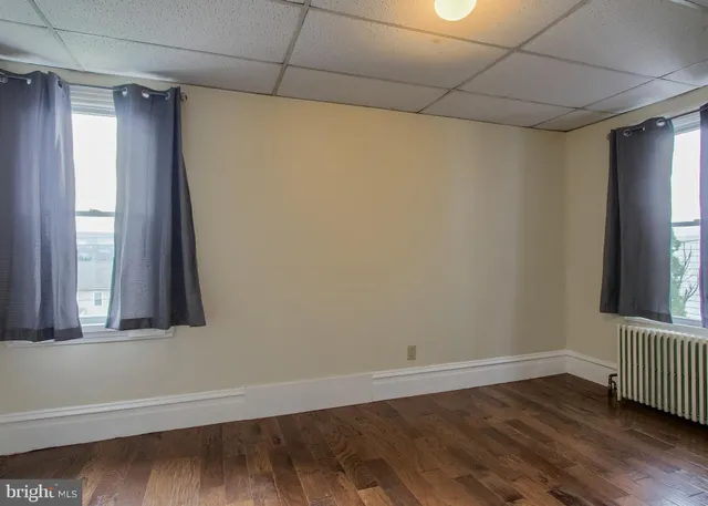 a view of a room that has wooden floor and a window