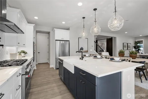 a large kitchen with a counter space a sink appliances and cabinets