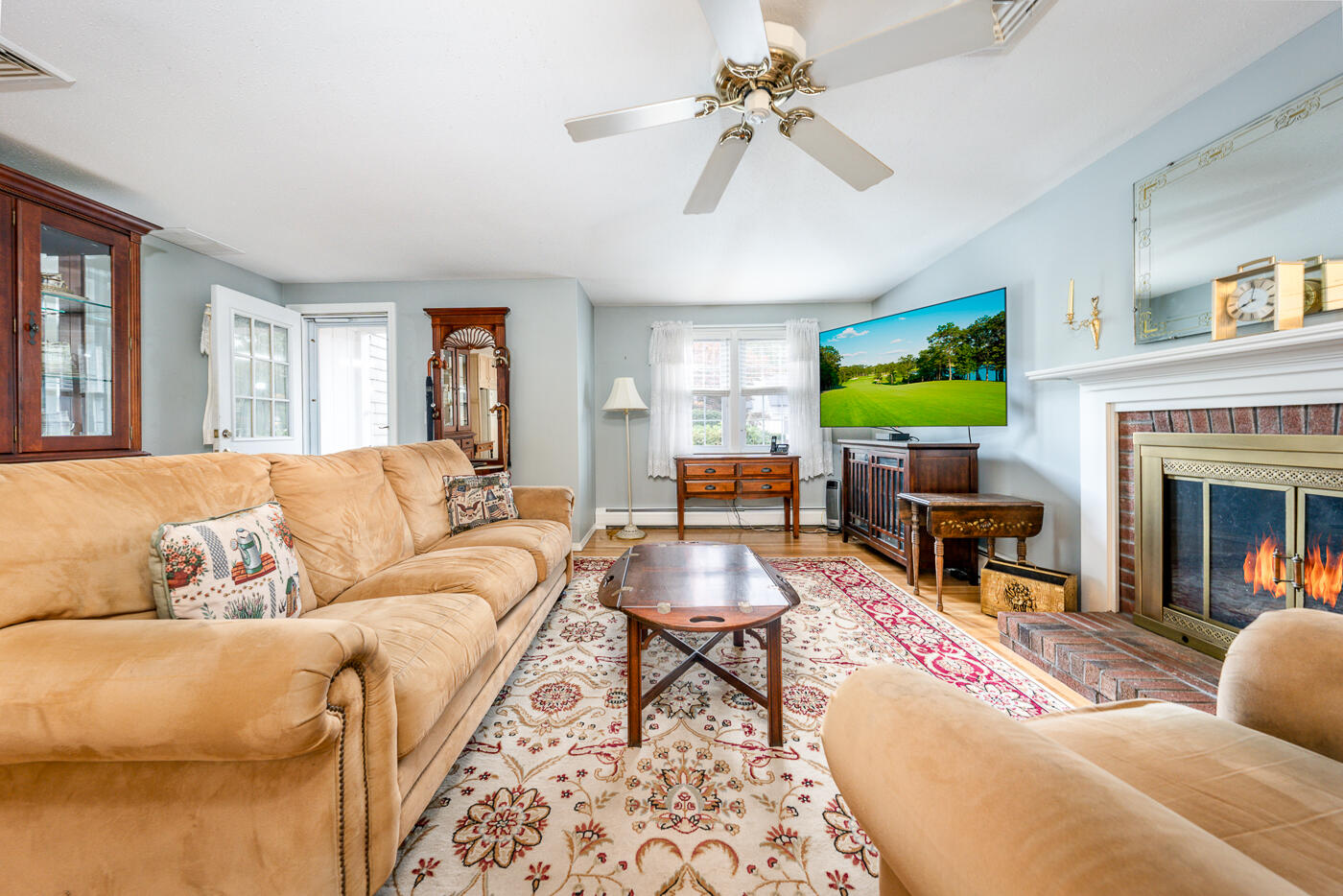 348 Prince Hinckley Road Centerville, MA 02632 - Photo 2 of 31 a living room with furniture a fireplace and a flat screen tv
