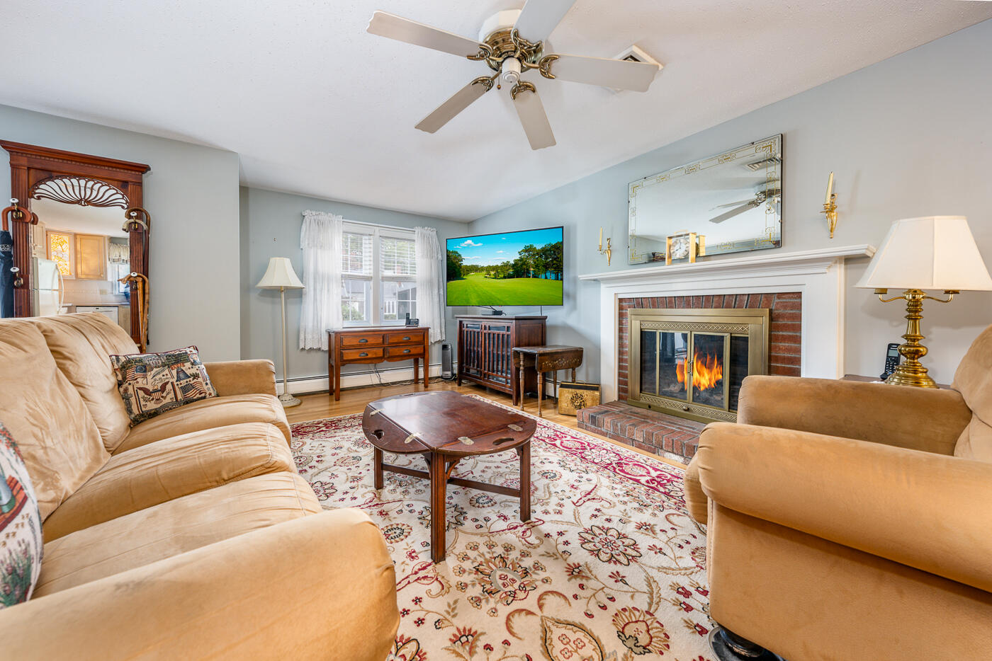 348 Prince Hinckley Road Centerville, MA 02632 - Photo 3 of 31 a living room with furniture a fireplace and a flat screen tv