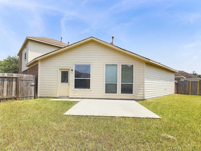 a front view of house with yard and trees in the background