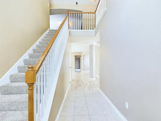 a view of staircase with railing and white walls