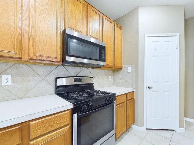 a kitchen with stainless steel appliances granite countertop white cabinets stove and microwave