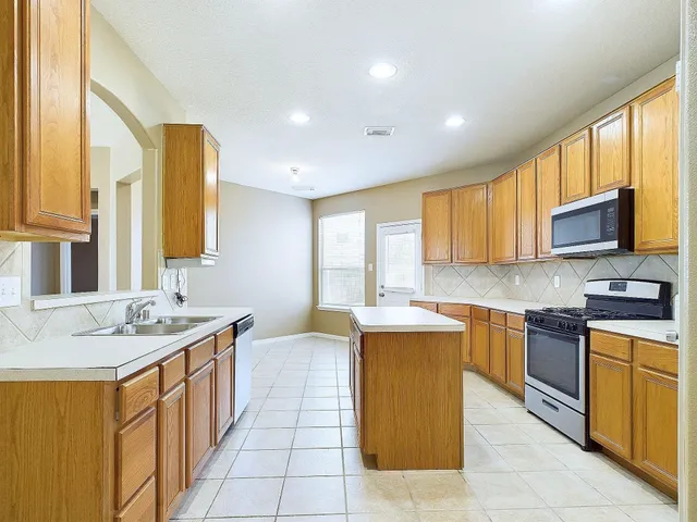 a kitchen with a sink stove and cabinets