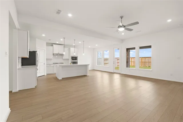 a view of an empty room with kitchen appliances and a window