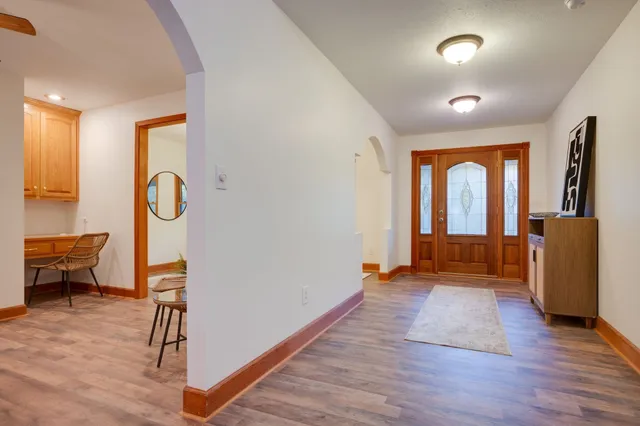 a view of a hallway with wooden floor and furniture