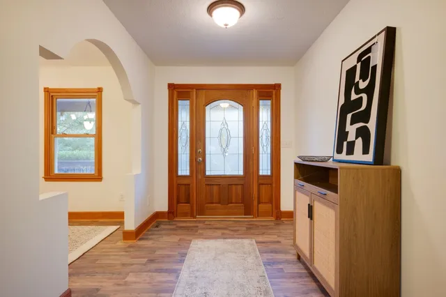 a view of a hallway with wooden floor and a living room