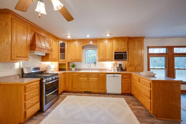 a large kitchen with a large counter top space appliances and cabinets