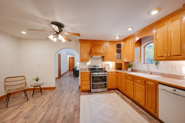 a kitchen with stainless steel appliances granite countertop a sink stove and refrigerator
