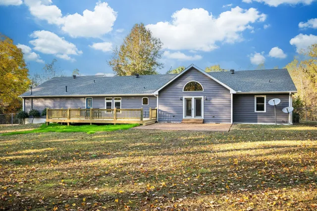 a view of a big house with a big yard and large trees