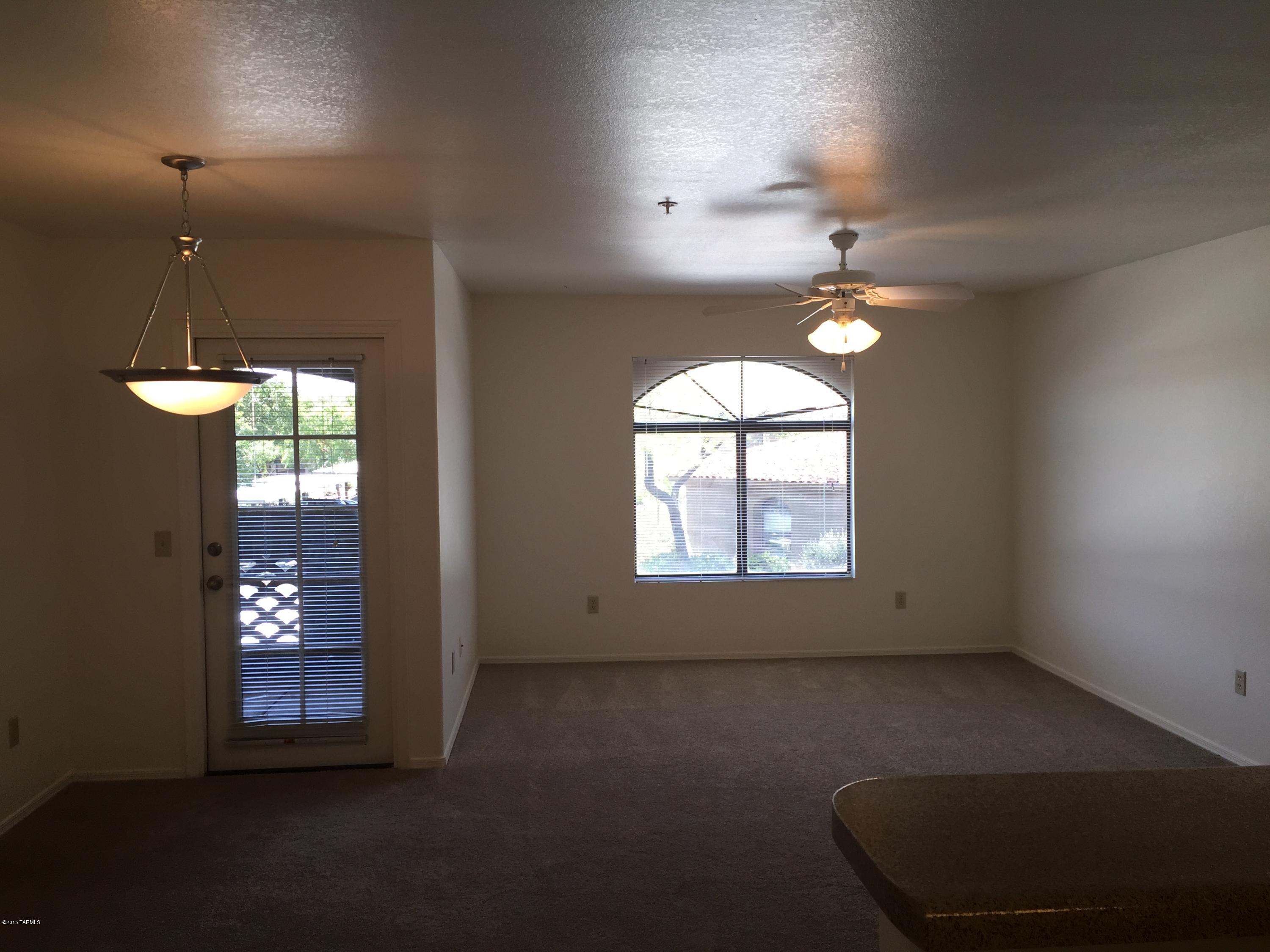 5751 North Kolb Road, Unit 28201 Tucson, AZ 85750 - Photo 5 of 14 an empty room with windows and chandelier fan