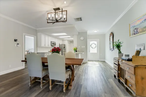 a dining room with furniture a chandelier and wooden floor
