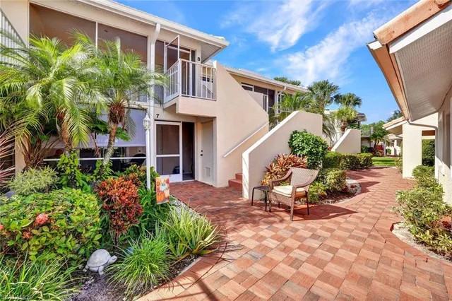 a view of a house with chairs and flower plants
