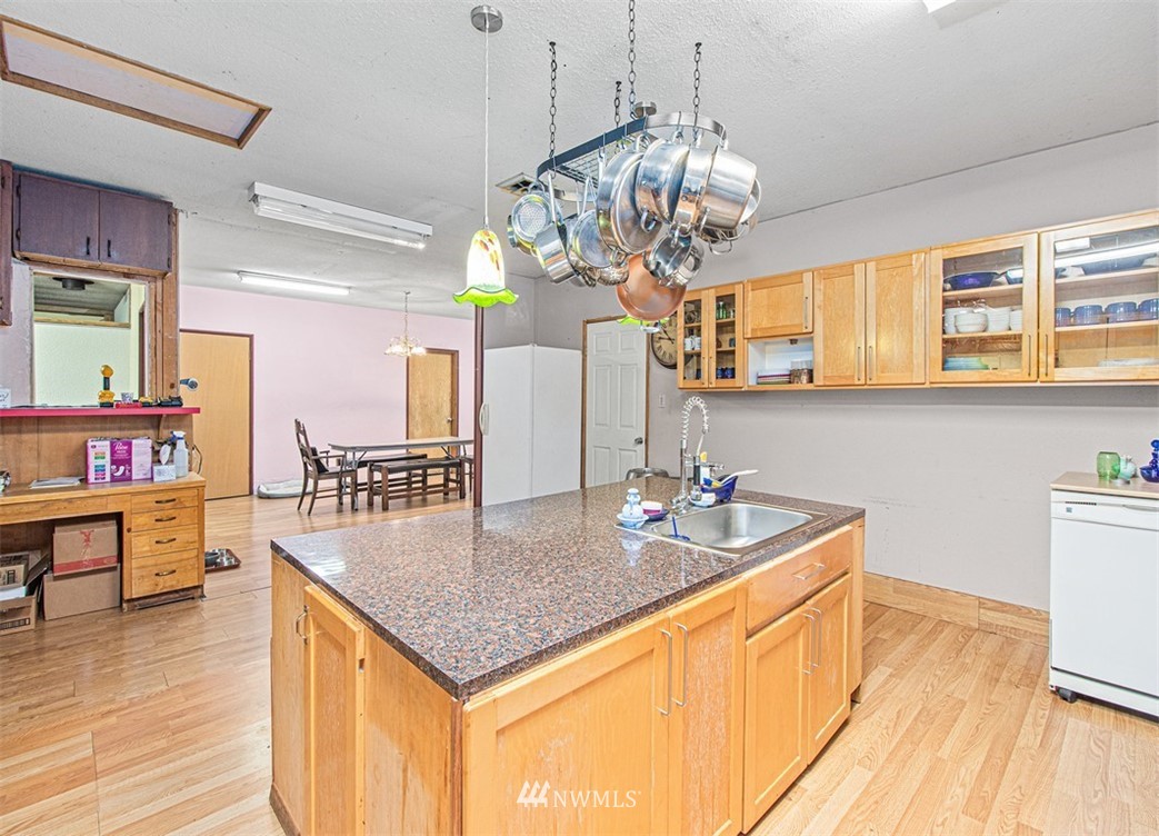 20128 Carper Road Southwest Rochester, WA 98579 - Photo 13 of 19 a kitchen with stainless steel appliances granite countertop a sink dishwasher and cabinets with wooden floor