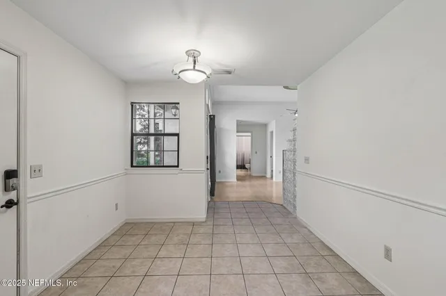 an empty room with a window and a ceiling fan