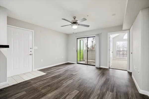 a view of an empty room with a window and wooden floor