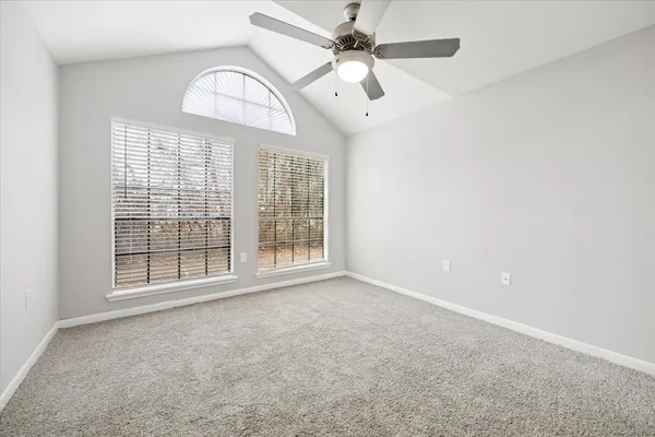an empty room with windows and fan