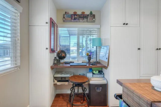 a view of a workspace with furniture and a window
