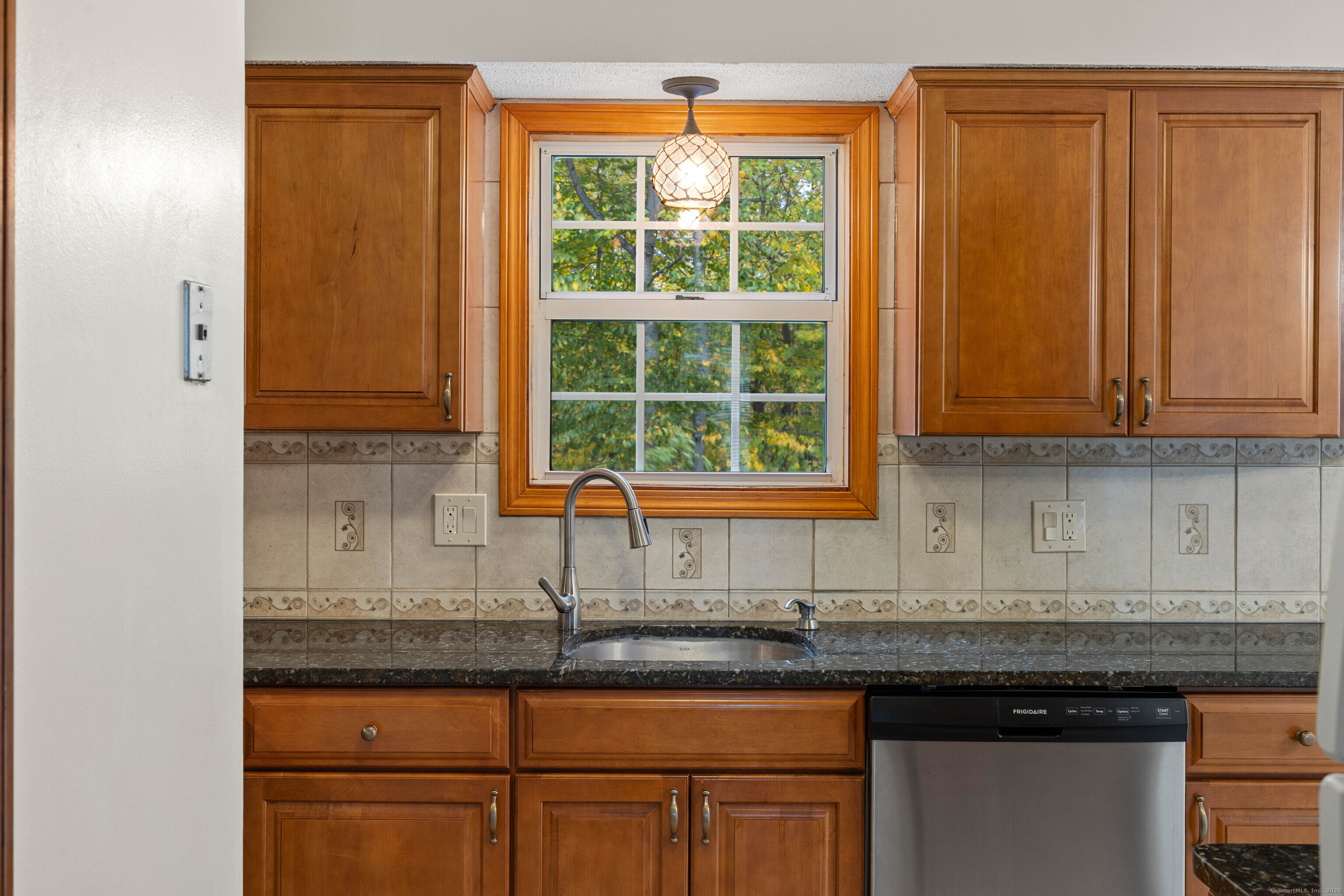 226 Austin Ryer Lane, Unit 226 Branford, CT 06405 - Photo 15 of 34 a kitchen with granite countertop wooden cabinets a sink and a window