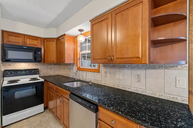 a kitchen with granite countertop cabinets stainless steel appliances and a counter space