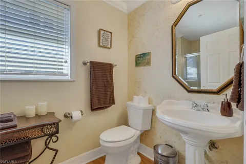 a bathroom with a toilet sink and mirror