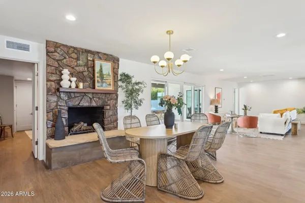 a view of a dining room and livingroom with furniture wooden floor a chandelier