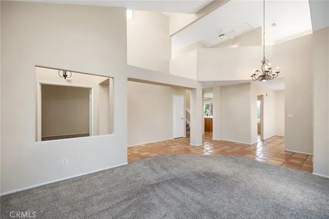 a view of a hallway with wooden floor and a chandelier
