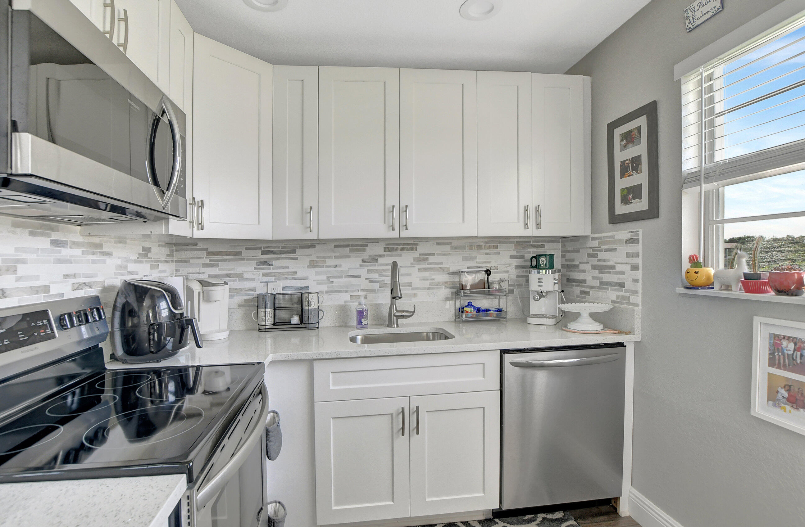 42 Brighton A Boca Raton, FL 33434 - Photo 2 of 24 a kitchen with stainless steel appliances granite countertop a sink stove and cabinets