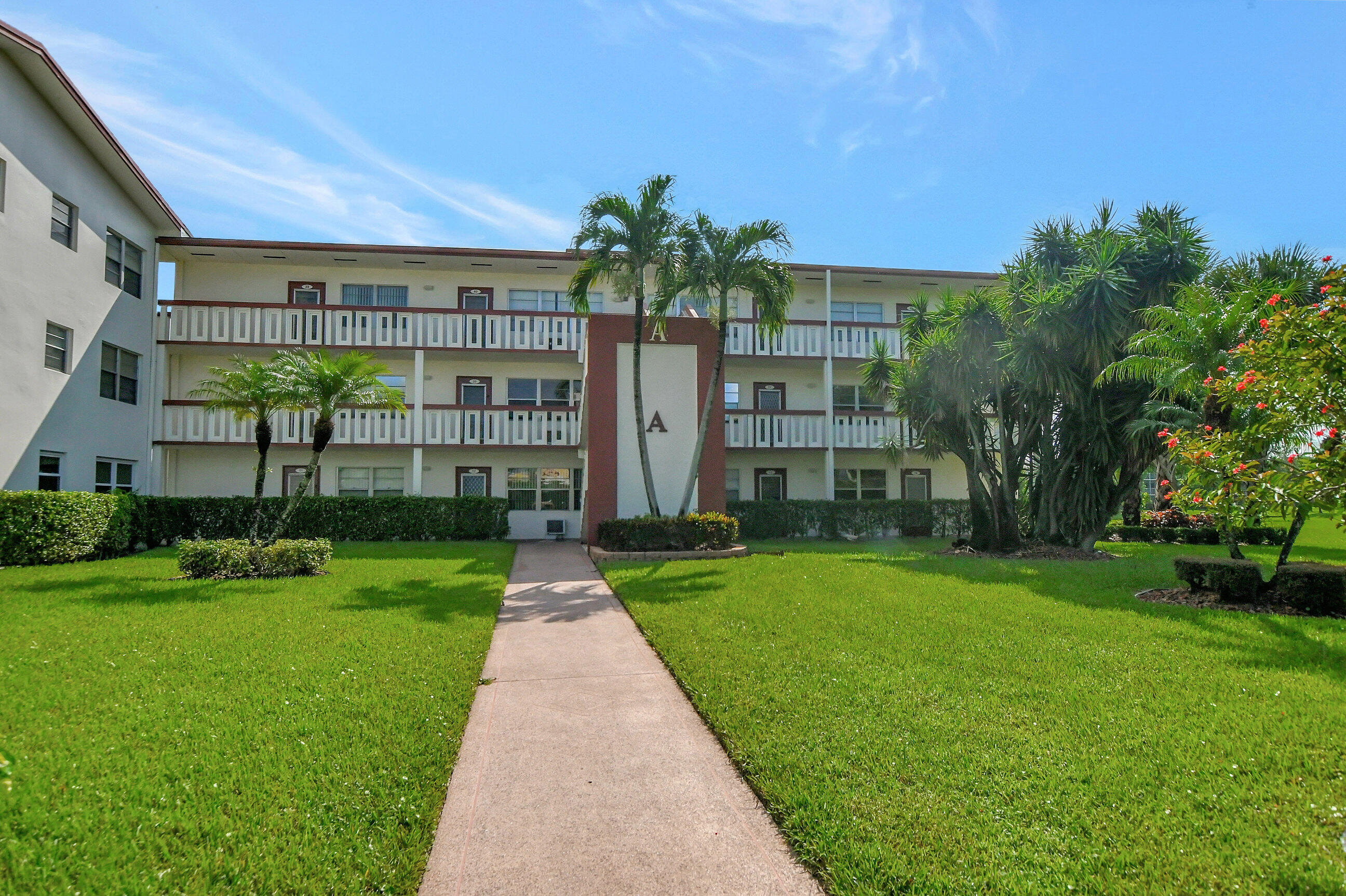 42 Brighton A Boca Raton, FL 33434 - Photo 22 of 24 a front view of a building with a garden