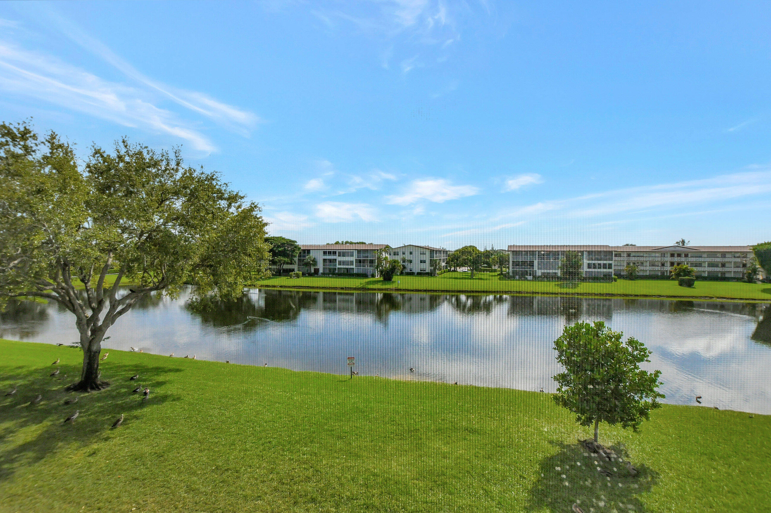 42 Brighton A Boca Raton, FL 33434 - Photo 23 of 24 a view of a lake with a house in the background