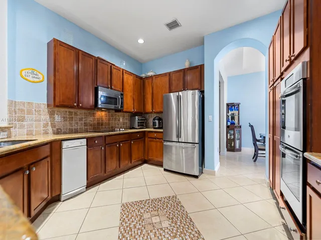a kitchen with a refrigerator a microwave a sink and cabinets