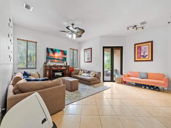a living room with furniture a flat screen tv and a window
