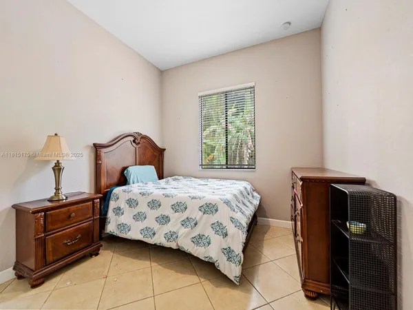 a bedroom with a bed and a tv on a dresser