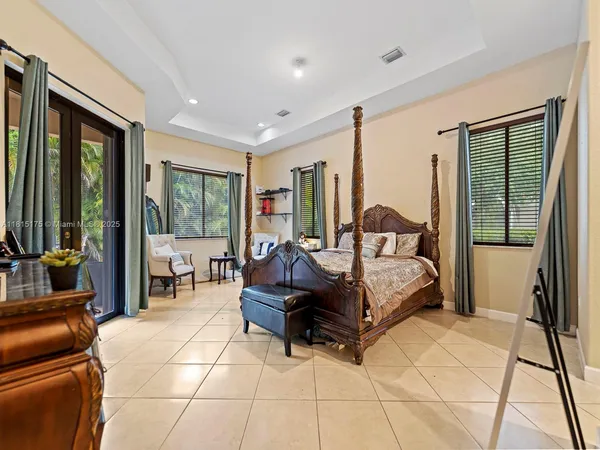 a spacious bedroom with a bed and glass door