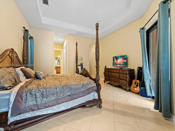 a bedroom with bed and a chandelier