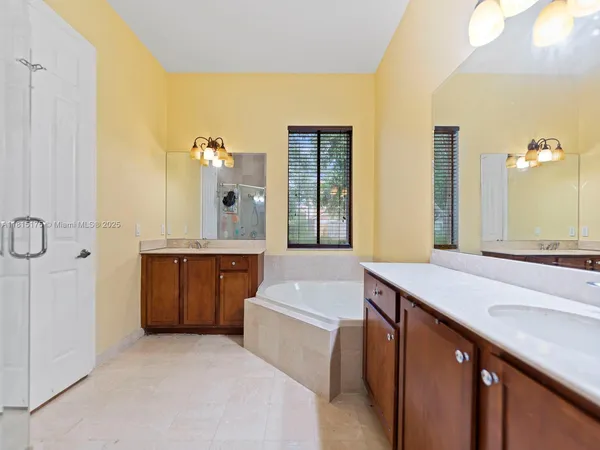 a bathroom with a tub sink and mirror