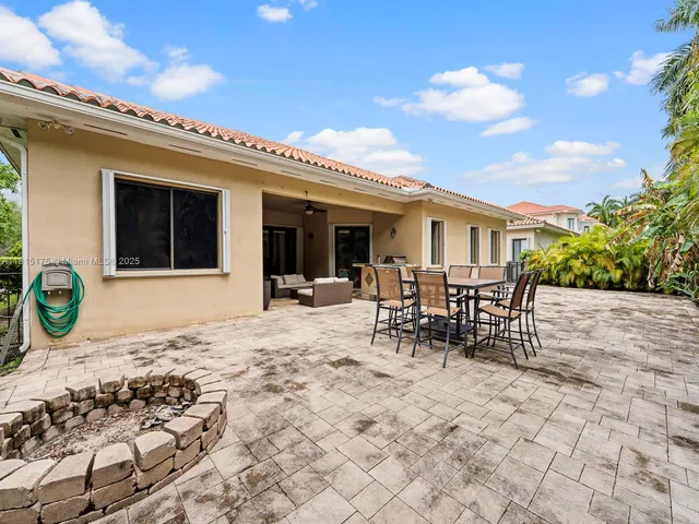 a view of a dinning table and chairs in the patio of the house