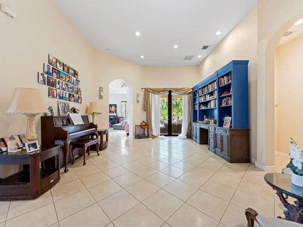 a living room with furniture a bookshelf and a large window