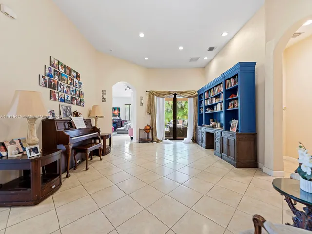 a living room with furniture a bookshelf and a large window
