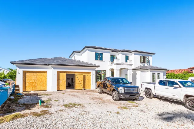 a front view of a house with cars parked