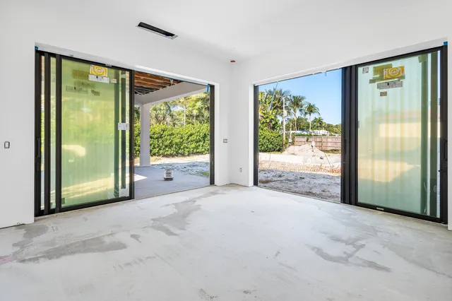 a view of a room with large windows and backyard of the house